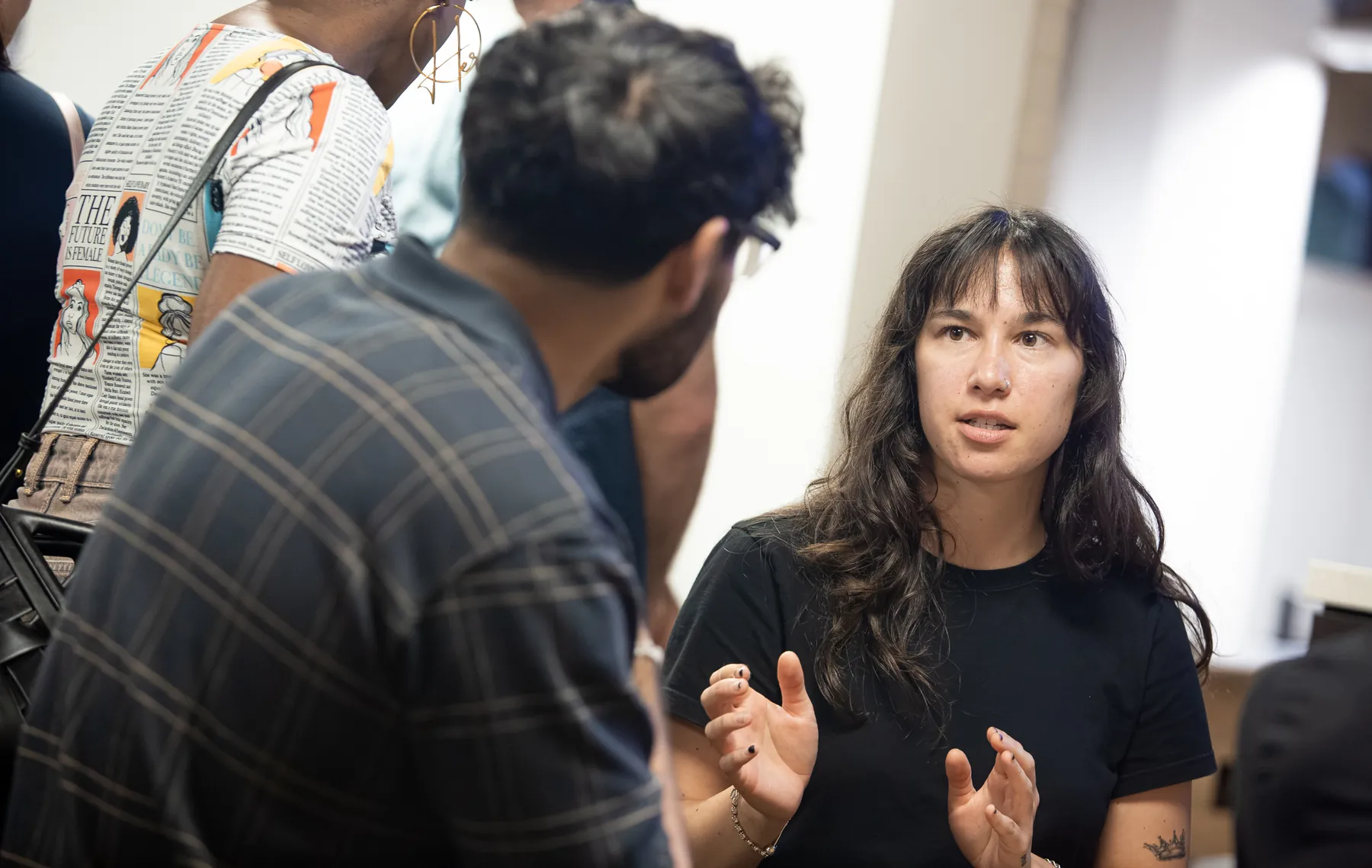 An attendee explains an idea with her hands during a small-group conversation