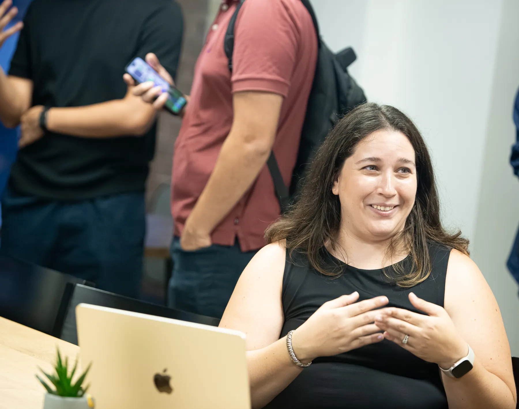 A community organization representative talks with volunteers around a laptop