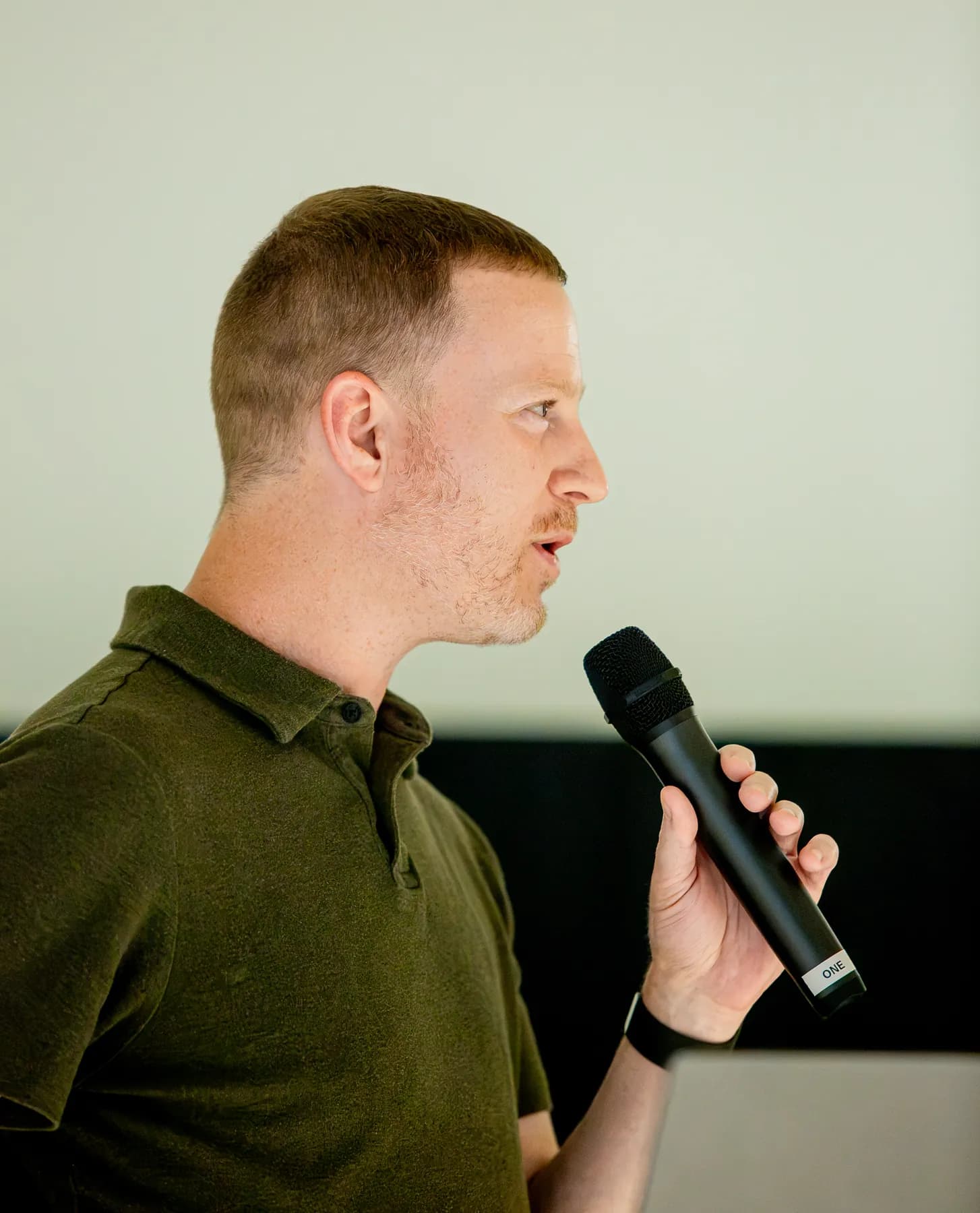A presenter speaks into a handheld microphone