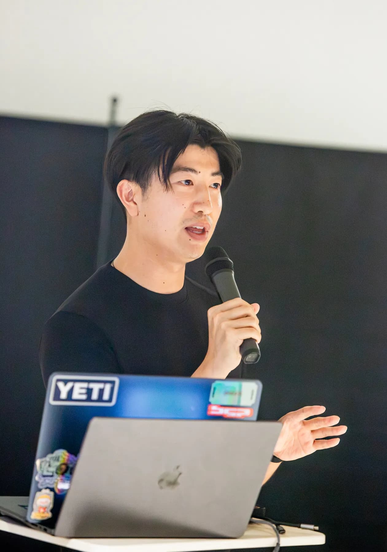 A presenter explains a project beside an open laptop
