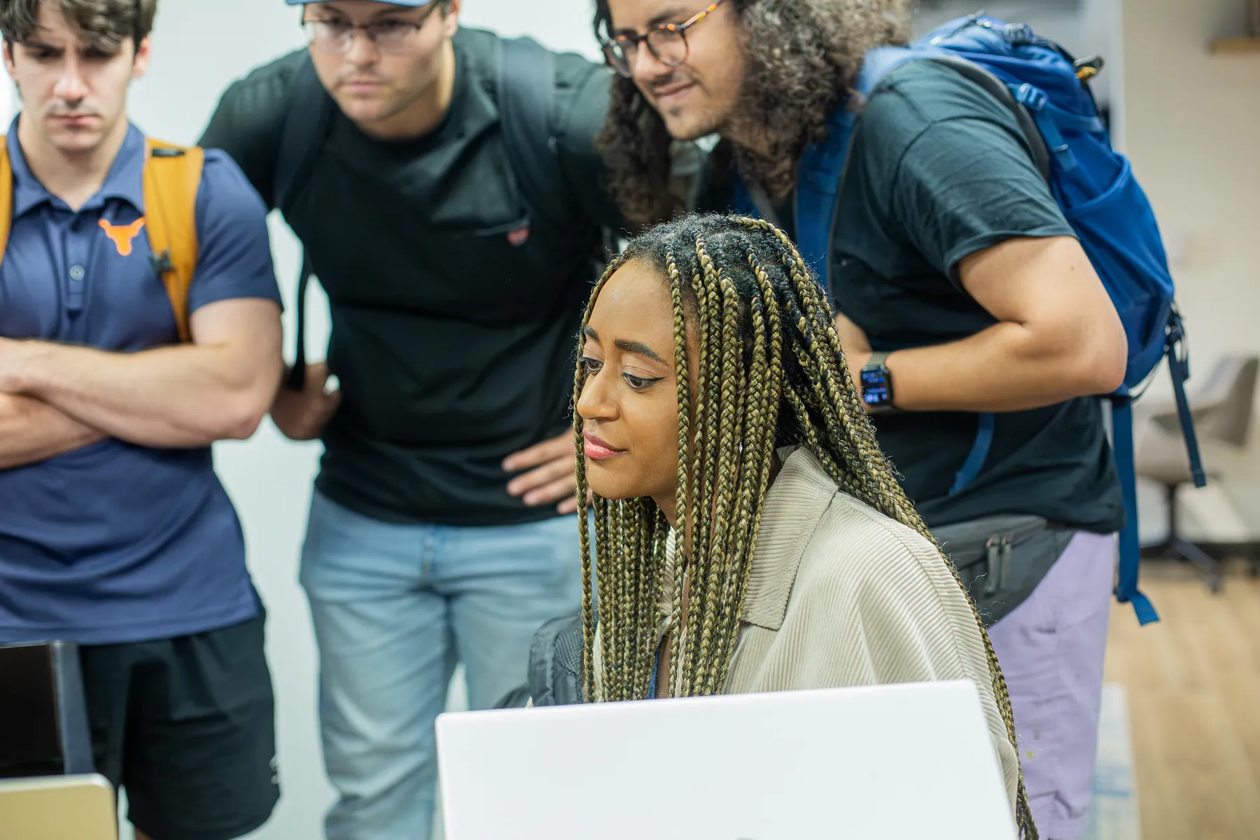 Volunteers and community organization representatives talk around a laptop