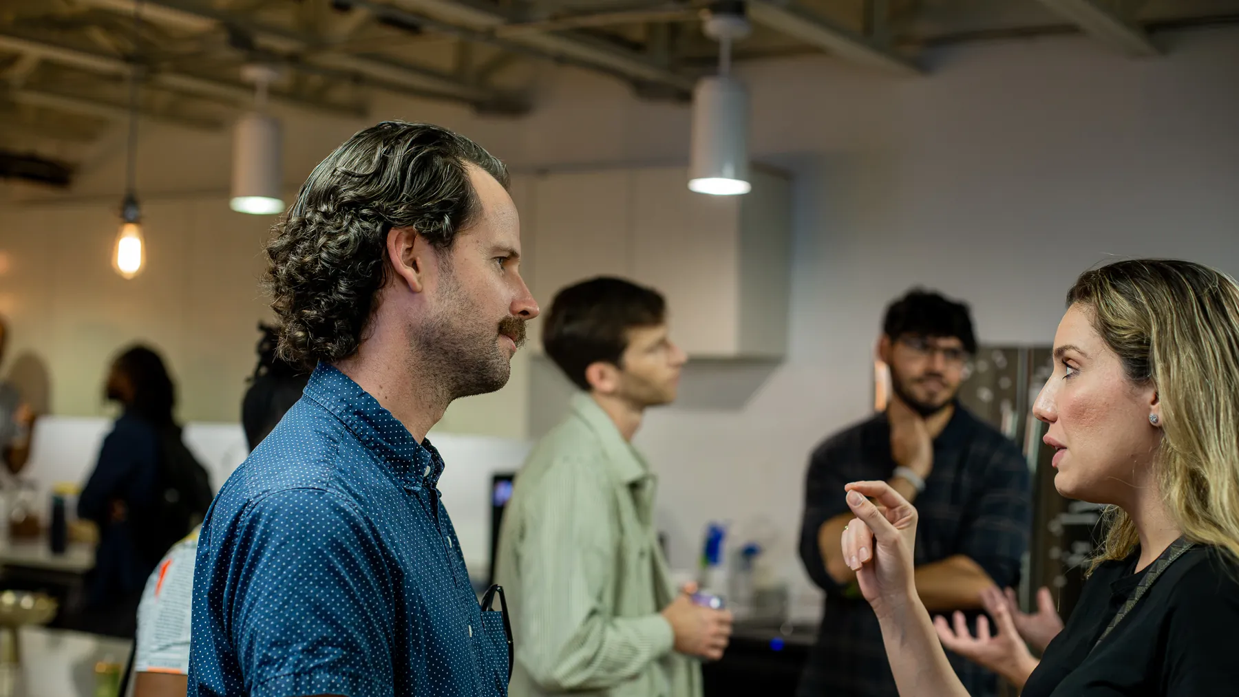 Two attendees continue a conversation as the room mingles
